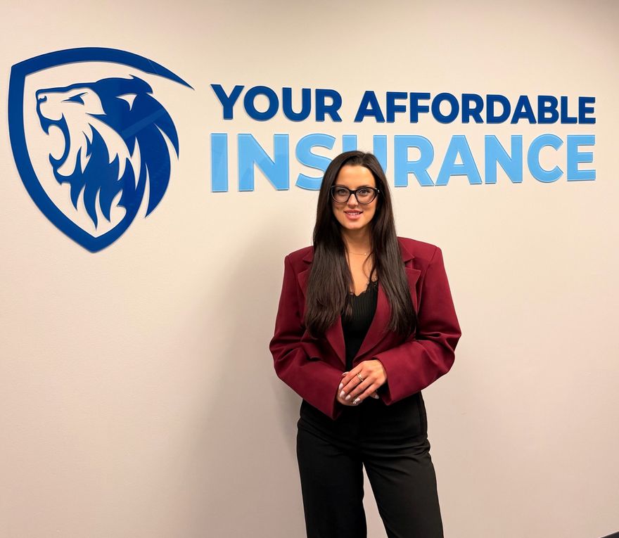 Your Affordable Insurance agent in the agency’s Rolling Meadows office, in front of the lion logo on the wall